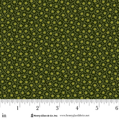 Fabric with a green and yellow pattern and a ruler at the bottom for scale.