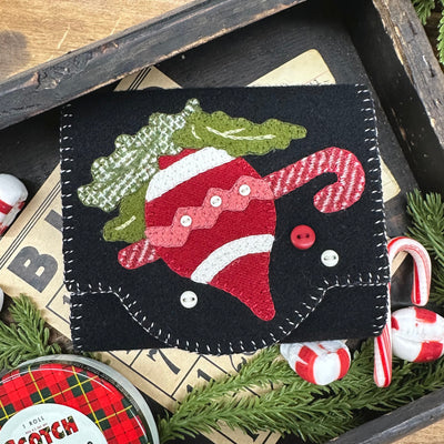 Festive felt ornament with a bulb, candy cane and holly leaves design.